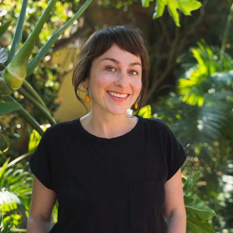 Heather Zortman smiling in a sunlit garden